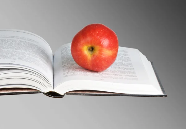 Rött äpple på öppen bok — Stockfoto