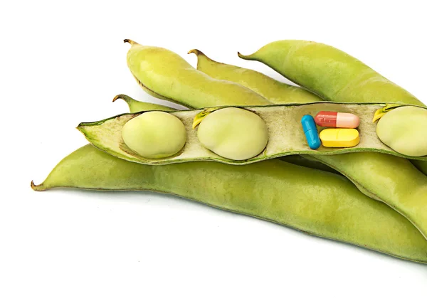 Pills in green beans as a symbol of green medicine — Stock Photo, Image