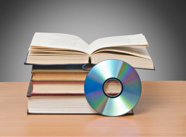 Open book and DVD as symbols of old and new methods of informat clipart