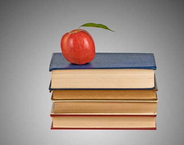 Manzana roja en un montón de libros — Foto de Stock