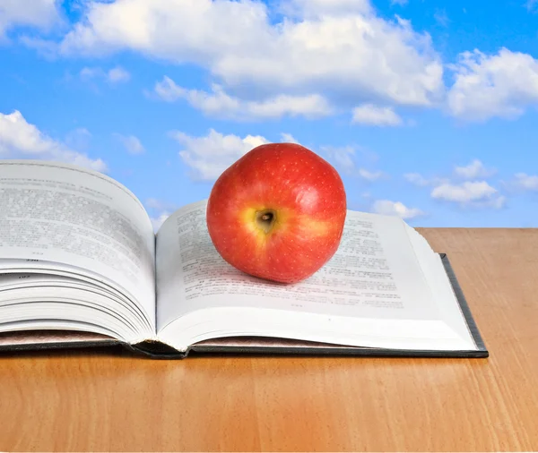 Roter Apfel auf aufgeschlagenem Buch — Stockfoto