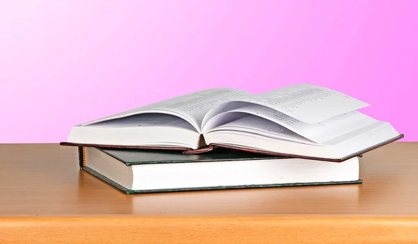 Buch aufschlagen auf Schreibtisch auf rosa Hintergrund — Stockfoto