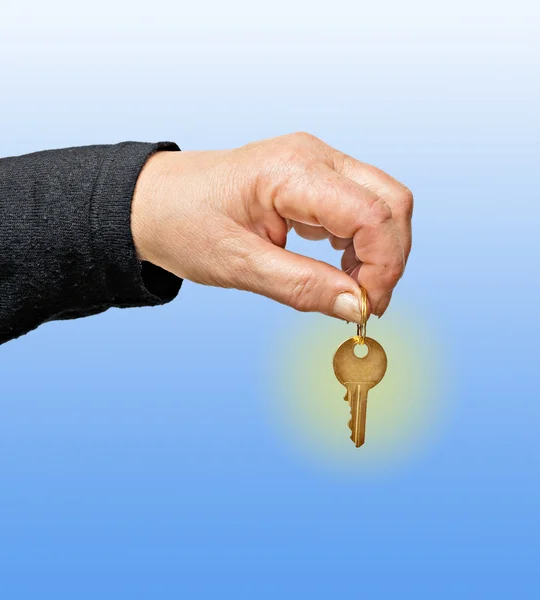 Fechar a mão segurando chave isolada no fundo — Fotografia de Stock