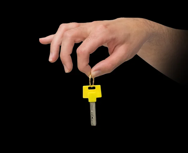 Mão segurando chave com arco amarelo — Fotografia de Stock