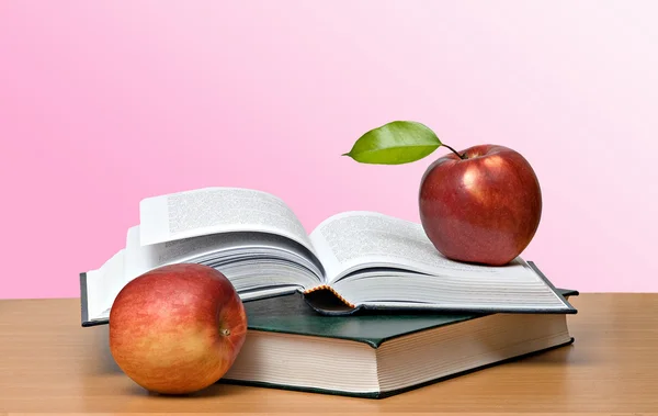 Röda äpplen och öppen bok — Stockfoto