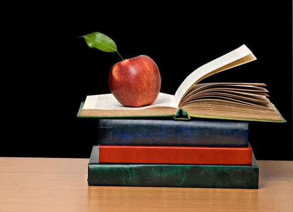 Красное яблоко и открытая книга — стоковое фото