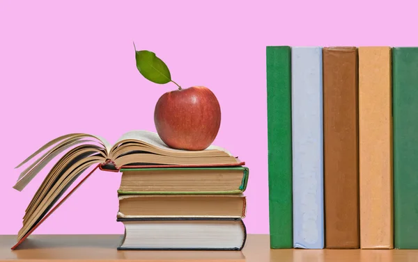 Rote Äpfel und eine Reihe Bücher — Stockfoto