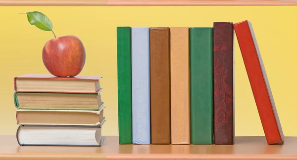 Rode appels en rij van boek — Stockfoto