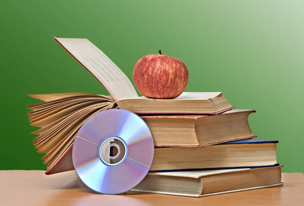 Apple, dvd en boeken als een symbool van de overgang van oud naar nieuw — Stockfoto
