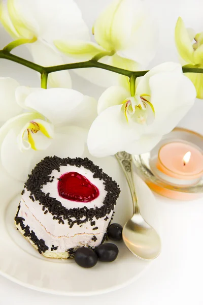 Tårta på bakgrund av en vacker orkidé — Stockfoto