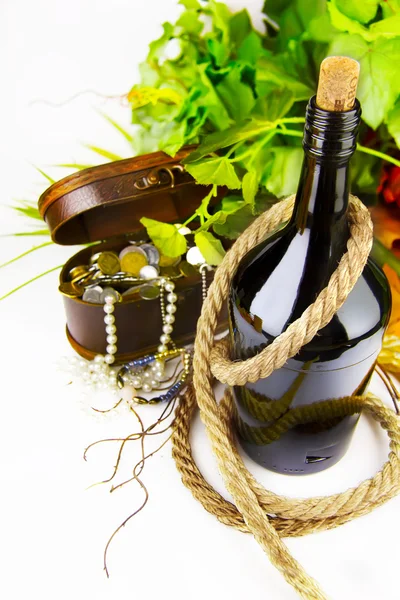 Bottiglia di vino contro il forziere con un tesoro — Foto Stock
