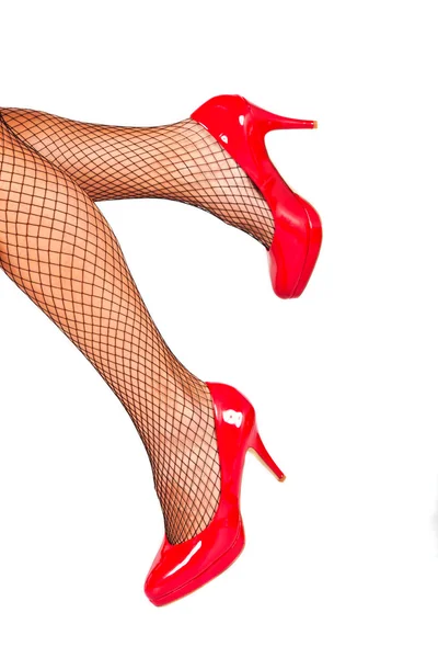 Rode schoenen met fishnet kousen — Stockfoto