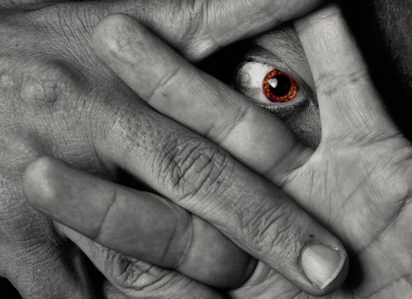 Occhio giallo che fissa attraverso le dita — Foto Stock