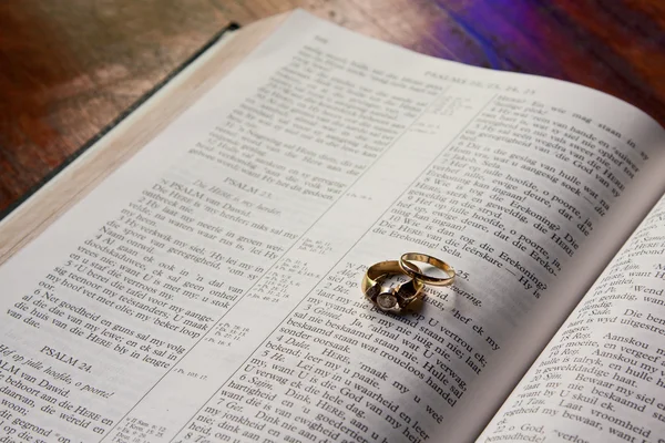 Wedding rings lying on Bible — Stock Photo, Image