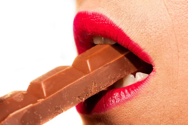 Mulher mordendo um pedaço de chocolate — Fotografia de Stock