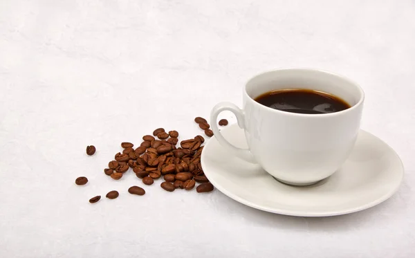 Café negro y granos de café marrón —  Fotos de Stock