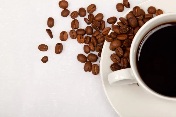 Tazza bianca, caffè nero e chicchi di caffè — Foto Stock