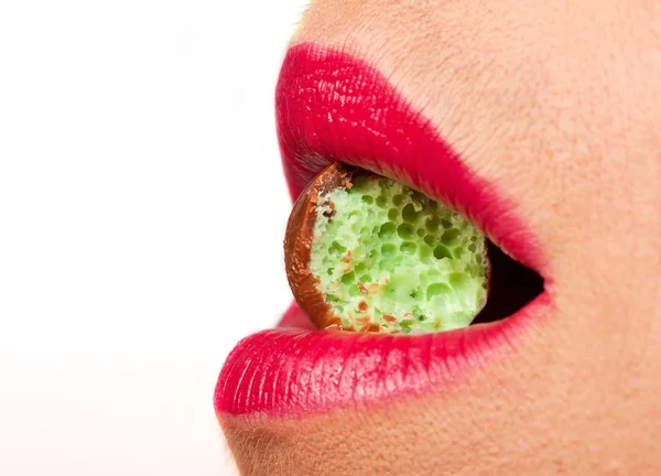 Woman biting green chocolate — Stock Photo, Image