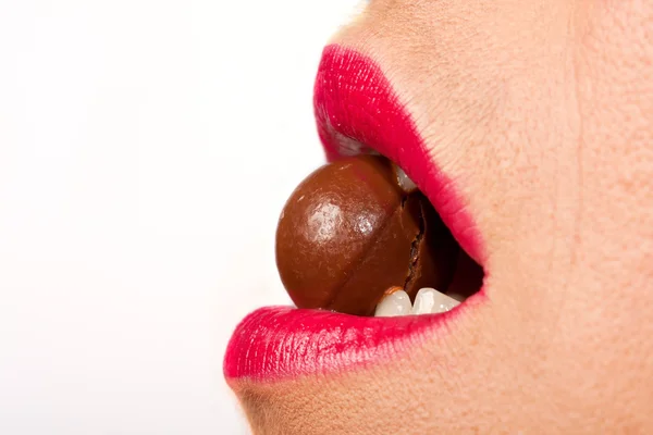 Vrouw bijten een ronde chocolade bal — Stockfoto