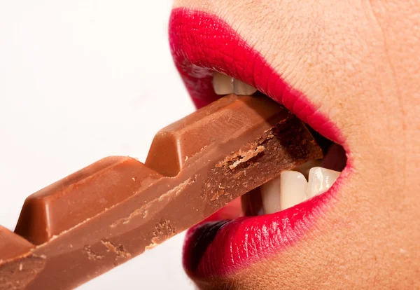 Kobieta z czerwonymi ustami jeść czekolady — Zdjęcie stockowe
