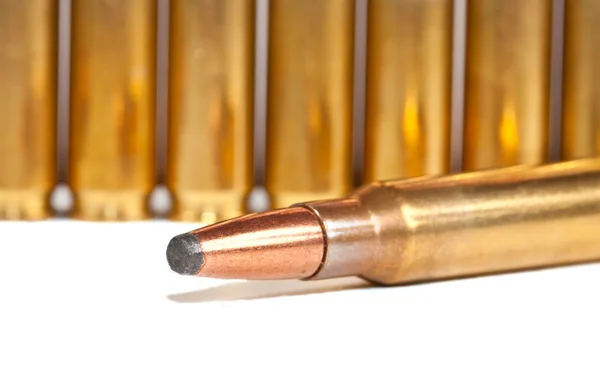 Una bala yaciendo frente a una fila de balas — Foto de Stock