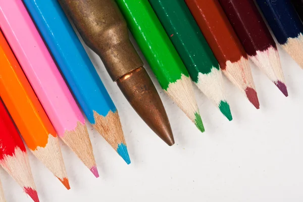 Gevär bullet liggande i rad med pennor — Stockfoto