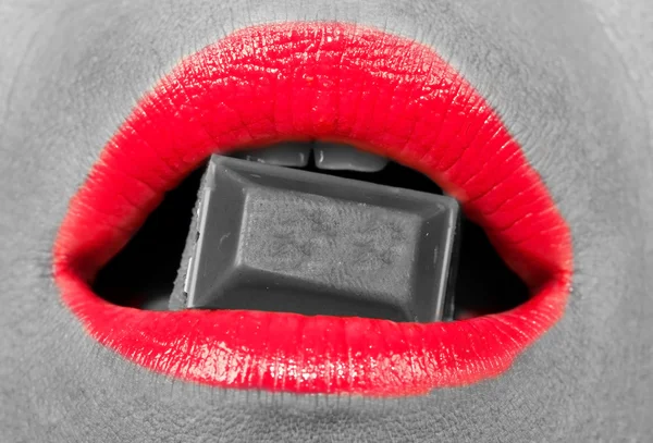 Mulher com lábios vermelhos mordendo um chocolate — Fotografia de Stock