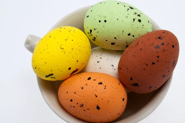 Цветные пасхальные яйца в белой чашке — стоковое фото