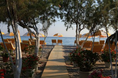 Two chairs and umbrella on the beach . Tigaki,Greece clipart