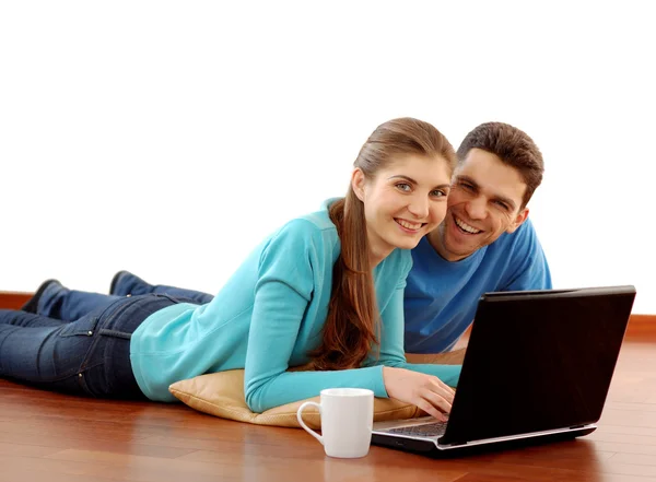 Uśmiechnięta młoda para korzysta z laptopa w domu — Zdjęcie stockowe