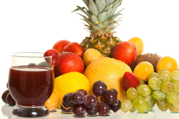 Verschiedene Früchte und ein Glas frischen Saft Stockbild