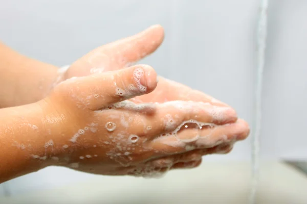 Petit garçon se lave les mains dans une salle de bain — Photo