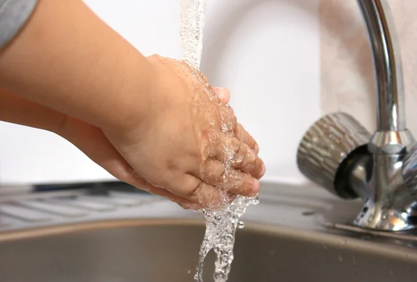 Niño pequeño se lava las manos en un baño — Foto de Stock