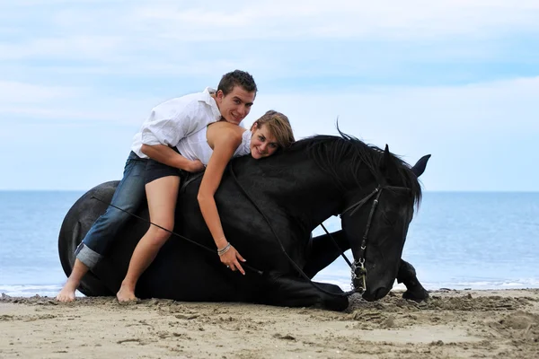 Paar und Pferd am Strand — Stockfoto