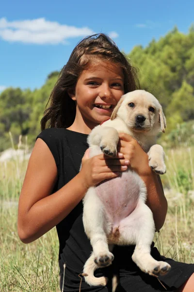 Köpek yavrusu labrador ve gülümseyen kız — Stok fotoğraf