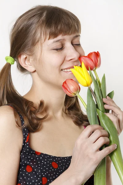 Das Mädchen inhaliert den Duft von Tulpen — Stockfoto