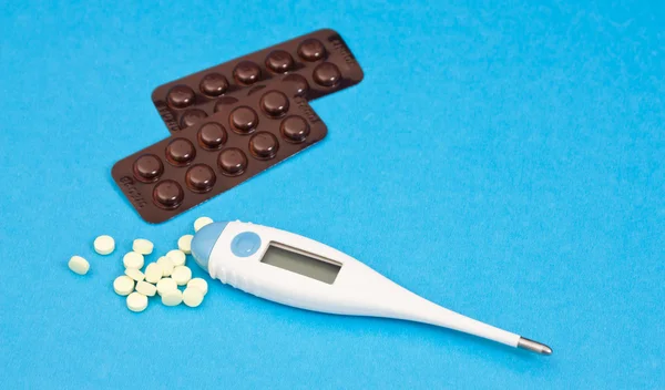 The medical thermometer and pills. — Stock Photo, Image