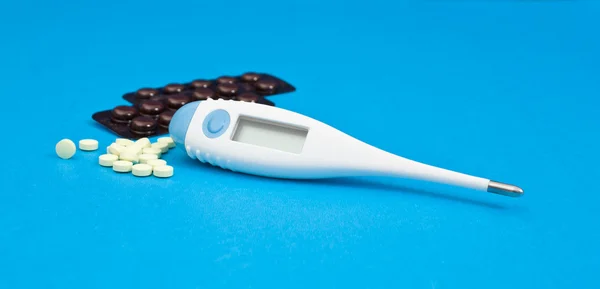 The medical thermometer and pills. — Stock Photo, Image