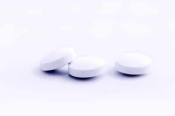 Garść białych tabletek na pokrywę — Zdjęcie stockowe