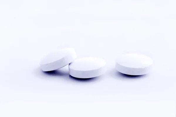 stock image Handful of white pills on a lid