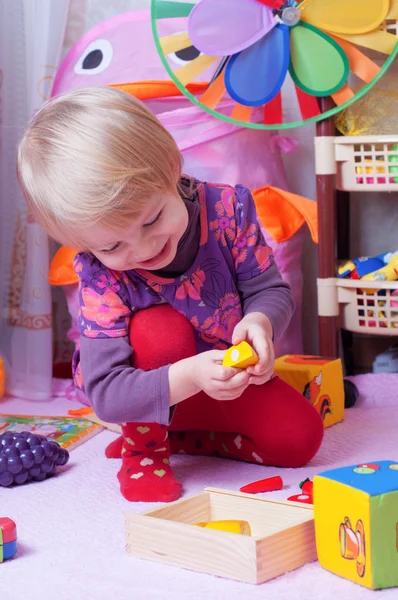 Menina na sala de jogos com brinquedos — Fotografia de Stock