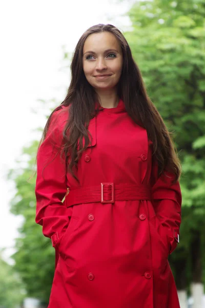 Vrouw met lang haar en rode loopgraaf — Stockfoto