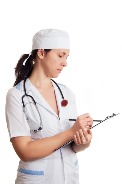 Médecin femme avec stéthoscope écrit dans les papiers — Photo