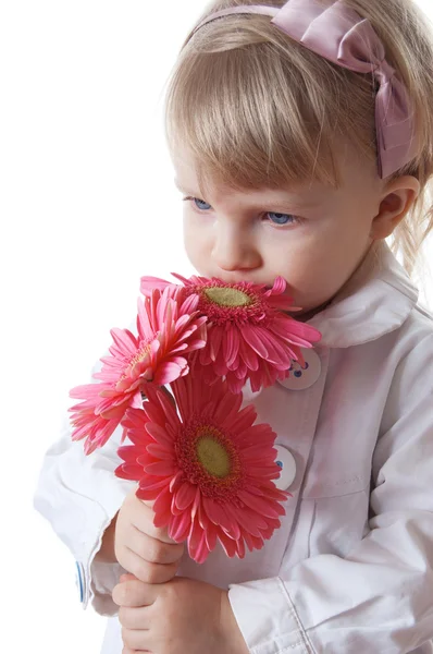 Pretty girl smelling pink gerbers — Stock Photo, Image