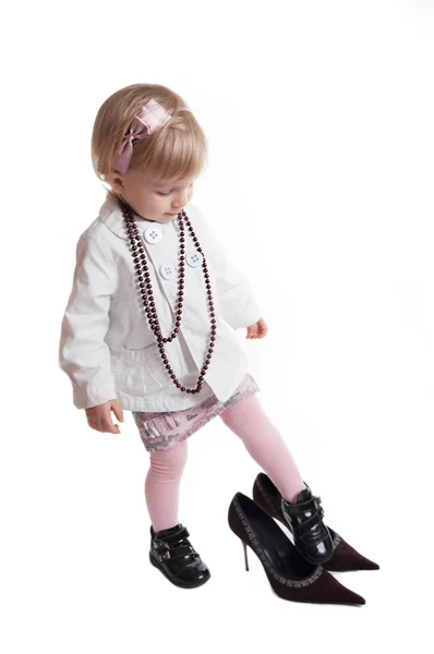 Little girl wearing mothers shoes and jewelry — Stock Photo, Image