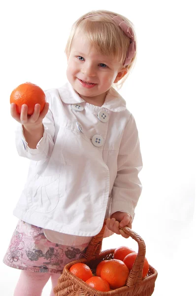 Little girl with fresh tangerines in basket — Stock Photo, Image