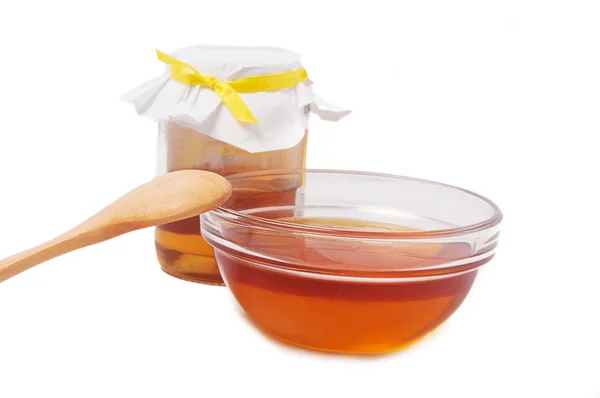 Frasco de mel com prato e colher de madeira — Fotografia de Stock