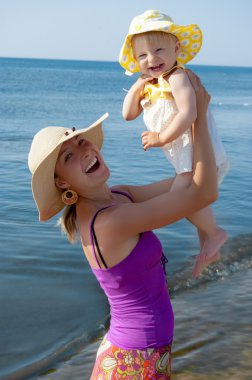 Joyful mother and daughter at beach clipart