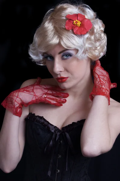 Blonde vrouw in korset met rode handschoenen — Stockfoto