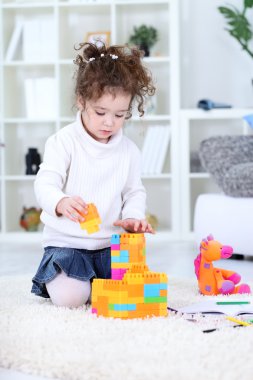 Little girl play with building blocks clipart